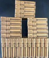 Complete 25-volume set of antique books showing uniform light beige cloth bindings with black printed titles on spine
