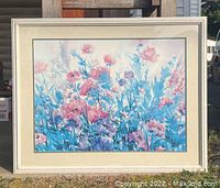 Full view of the framed floral painting outside to show overall condition and size proportion.