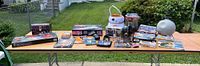 Overview photo showing entire assortment of Star Wars toys and collectibles on table outdoors.