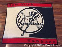 Full view of the rectangular fleece throw showing New York Yankees logo and text along borders in red, black, and white.
