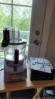 Full view of Cuisinart food processor with base, bowl, lid, and stacked accessories on table