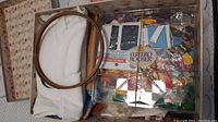 Box with wooden embroidery hoops on top, assorted colorful thread packs and fabric pieces below