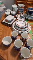 All 26 pieces displayed on table including plates, bowls, cups, teapot, sugar bowls, creamer, salt & pepper, butter dish, platter