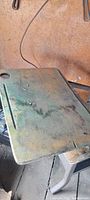 Close-up of antique wooden school desk with worn surface and groove for pencils.