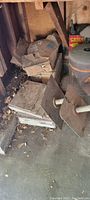 Boxes of old flooring tiles and other materials in storage corner with dirt and debris.