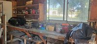 Garage workbench and shelving with various cans, paints, lubricants, and containers