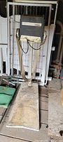 Full view of the metal rowing machine showing metal frame, padded base, and handles.