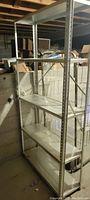 Large metal garage shelf with four adjustable shelves in dusty condition