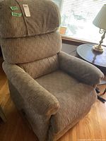 Front view of the La-Z-Boy recliner in brown fabric, showing the cushioned armrests and backrest with minor pilling on upholstery.