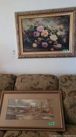 Floral canvas print with ornate gold frame mounted on wall above couch, showing overall condition and style.
