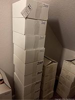 Stack of ten cardboard boxes labeled by year from 2000 through 2009 containing magazines