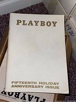Box of the Playboy Fifteenth Holiday Anniversary Issue with embossed logo and gold lettering on white background.