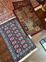 Three small machine-made area rugs arranged on a hardwood floor, showing different designs and colors.