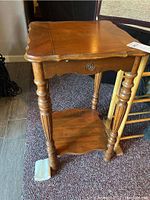 Vintage wooden lamp table with marquetry inlay top, scalloped edges, and turned legs