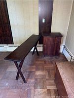Photo showing vintage sofa table and cabinet side by side on wood parquet floor against paneled wall.