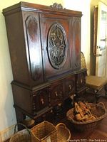 Front view of the vintage china cabinet showing its overall size and dark wooden finish with ornate lower doors.