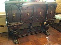 Front view of dark wood Mohlhenrich server showing carved panels and brass hardware