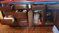 Open cabinet and drawers showing storage containers and various baking and cooking pans