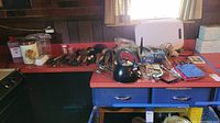 Full overview of kitchen tools and utensils on countertop including teapot, canisters, cutting tools, and potholders.