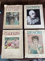 Four vintage art books placed flat, covers and jackets visible, showing artists Toulouse Lautrec, Daumier, Gauguin, and Renoir