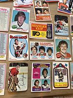 Close-up photo of assorted vintage hockey cards featuring players like Terry O'Reilly, Ken Dryden, Bernie Parent, Phil Esposito, and others, showing front designs and player portraits.