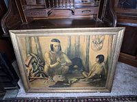 Front view of the framed print depicting a Native American craftsman and child with a decorative blanket and a rustic interior background.