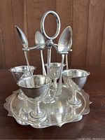 Silver plated egg cup carousel with four egg cups, shown from front angle.