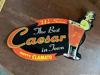 Full front view of tin sign showing text and cocktail illustration.
