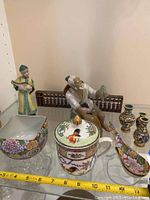 Asian themed figurines including musicians, small wooden abacus, lidded cup with rooster, floral bowl and soup spoon