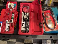 Open red plastic carrying case showing Craftsman rotary tool, cord, and accessories organized in removable tray on lid.