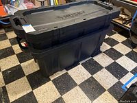 Two black Husky storage bins stacked, showing overall size and condition