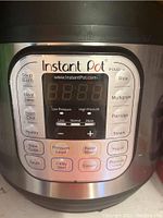 Close up of Instant Pot IP-DUO front control panel showing various cooking function buttons and LED display.
