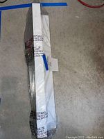 Photo of Pottery Barn Holman ledge still packaged in plastic and cardboard, showing the white ledge length.