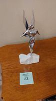 Full view of Hoselton aluminum fairy sculpture on white stone base, front and side angles.