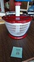 Front view of KitchenAid salad spinner placed on a table with a Maxsold lot number.