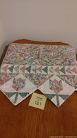 Photo of folded fabric mantle runner showing floral pattern and geometric triangle strip