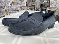 Side and angled view showing blue suede material, stitching details, and overall condition.