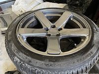 Close-up of a silver 5-spoke alloy wheel showing curb rash along the rim edge and mounted Continental WinterContact tire