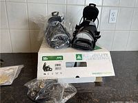 Front view of the pair of K2 Sonic snowboard bindings on box with mounting hardware in plastic bags.