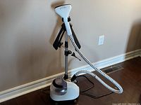 Full view of the Cirago upright garment steamer standing upright with hose attached and collapsible steam head.