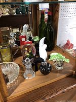 Lower display shelf with variety of glassware and figurines