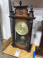 Full view of the Linden wooden wall clock showing its wooden case, dial, and pendulum.