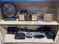 Overview of the assorted analog and digital clocks on shelves, showing various styles and sizes of clocks from different brands.