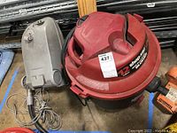Photo showing gray Kenmore vacuum model 116.2003590 and red/black Shop-Vac unit on floor