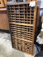 Front view showing multiple small compartments of the vintage wooden printer tray.