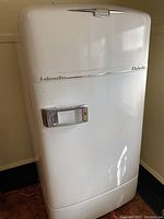 Full view of the white vintage Crosley Shelvador refrigerator with chrome handle and lettering.