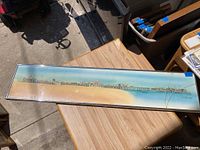Full view of framed artwork showing Santa Monica Pier panoramic scene with cracked glass damage visible.