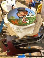 First plate showing cartoon man riding horse confronting lobster with castle and trees background, sitting on paper towel with wooden stand below