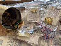 Pins inside a metal container with some pins sealed in plastic bags with UNOCAL branding and explanatory inserts.