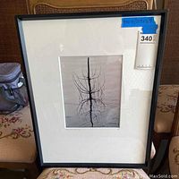 Full view of framed photo art showing the black frame and white mat with photo of tree reflection in water.